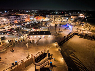 Pismo Beach, California, As seen from a UAV Drone at night looking at City Downtown and the Pier Beach Area with the colorful lights of the night.