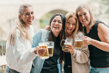 Cheerful women with friends drink beer at a lively summer party in Bavaria Germany celebrating culture joy leisure and fun