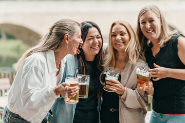 Friends celebrate with beer as a group of women gather at a summer party in Bavaria Germany enjoying fun laughter and joy