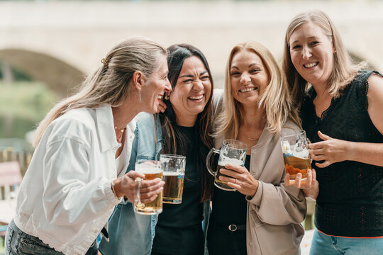 Friends celebrate with beer as a group of women gather at a summer party in Bavaria Germany enjoying fun laughter and joy