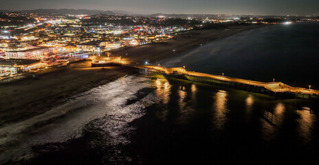 Pismo Beach, California, As seen from a UAV Drone at night looking at City Downtown and the Pier Beach Area with the colorful lights of the night.