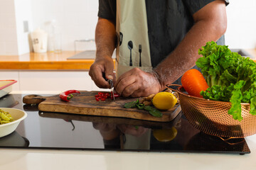 Close-Up of Hands Cutting Fresh Red Chili on Wooden Cutting Board