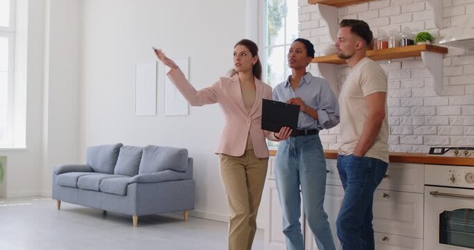 Concentrated realtor or real estate agent presenting new home or apartment to family couple, showcasing property for purchase, guiding clients, offering professional insight in real estate.