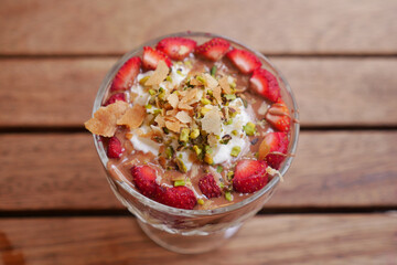 Delicious dessert with strawberries and nuts in a glass bowl