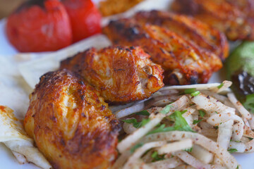 Grilled chicken served with vegetables and salad on a plate