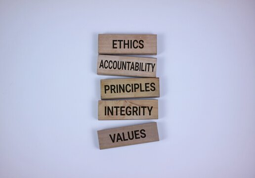 Wooden blocks stacked with words representing ethics, values, accountability, and principles, set against a white background symbolizing morals and foundational virtues.