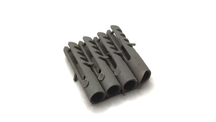 four grey plastic wall plugs or anchors or rawlplugs isolated on white background