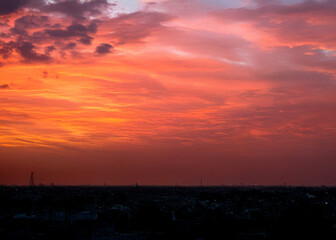 Lahore skyline at sunset with ominous red sky and dramatic motion, capturing the city's silhouette against a vibrant orange and pink hues backdrop,