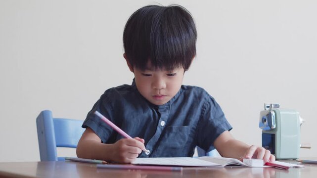 ひらがなのを書く練習をする5歳の男の子	