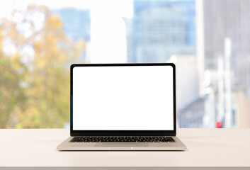 close up blank white screen display of laptop computer on table in office building with garden scene for add content of design banner,website or template or online shopping e-commerce concept