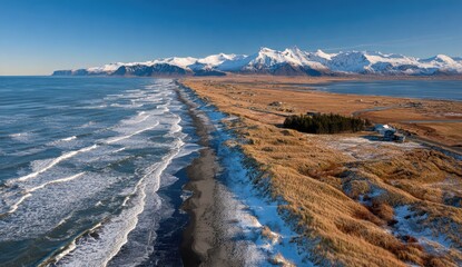 Black sand beach meets snowy mountains.  Vast ocean vista