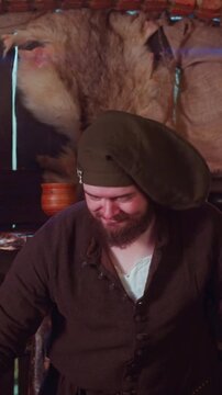 Merchant sells goods to adventurers in tavern. Positive seller with overweight makes trading deal with pilgrim guests in medieval inn. Buy artefacts