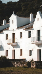 Charming traditional white buildings bathed in warm sunlight, showcasing rustic architecture and tranquil surroundings under a clear blue sky, perfect for a serene getaway