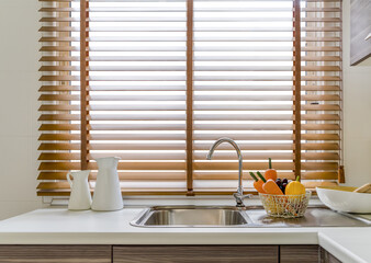 Sink in the modern kitchen, windows decorated with wooden blinds
