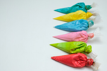 Colorful icing piping bags arranged on a white background, ideal for baking, cake decorating, and creative culinary projects