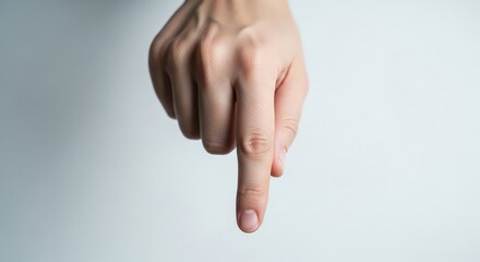 Close-up of a fair-skinned person's index finger pointing downwards.