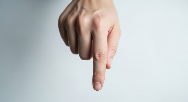 Close-up of a fair-skinned person's index finger pointing downwards.