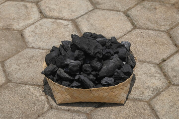 Close up of a pile of charcoal in a woven bamboo container. For graphic design, 3D rendering and banners