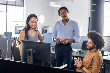 Fototapeta premium Diverse business team collaborating on project at modern office workspace