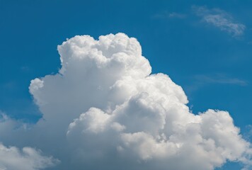 A large, fluffy white cumulus cloud floats serenely against a brilliant, clear blue sky, suggesting a warm summer day with fair weather