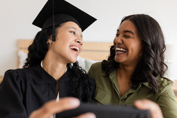 Graduation day, mother and daughter laughing and taking selfie at home
