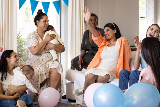 Women celebrating baby shower with balloons, smiling and enjoying moment together - Powered by Adobe