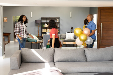Holding balloons and celebrating, friends gathering at home for lively conversation