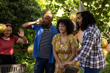 Celebrating birthday outdoors, friends wearing party hats with balloons, festive moment