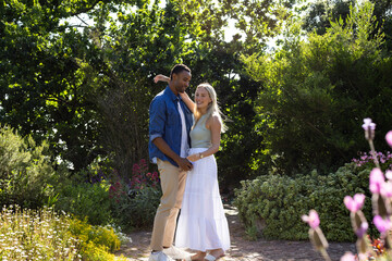 Couple enjoying romantic moment in lush garden surrounded by vibrant flowers