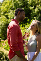 Fototapeta premium Couple enjoying outdoor celebration, smiling and toasting with champagne glasses