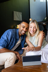 Couple video chatting on tablet, smiling and enjoying time together at home