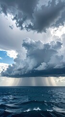Dramatic seascape with rain falling under a huge cloud formation, ocean waves visible, creating a powerful, serene vista