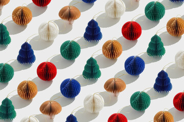 Minimal pattern of colorful paper Christmas ornaments shaped balls and Christmas tree, stylish holiday backdrop. Festive texture of paper Honeycomb baubles. Merry Christmas and Happy New Year concept.