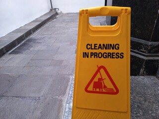 A yellow board is used to inform that the area is in the process of being cleaned