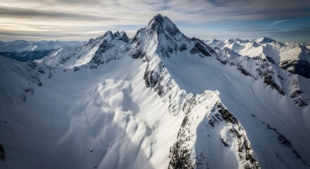 A breathtaking aerial vista of snow-capped mountain peaks and valleys, showcasing rugged terrain and pristine white snow.