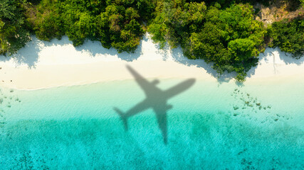Aerial view of shadow passenger plane silhouette and sandy beach blue sea with waves at sea beach summer vacation sea travel concept	