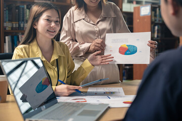 Business colleagues pointing at business document during discussion at meeting. Business people meeting explaining the financial graph data and marketing plan.Teamwork process.