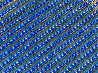 Obraz premium Rows of empty blue stadium seats creating a geometric pattern in an outdoor sports arena.