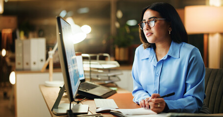 Writing, night and woman in office with desktop, note taking or problem solve in company analysis. Productivity, graph and data analyst in workplace with tech, solution strategy or info in overtime