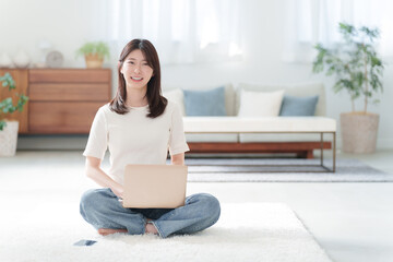 家でパソコンを使って仕事する女性