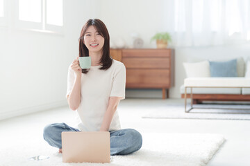 家でパソコンを使って仕事する女性