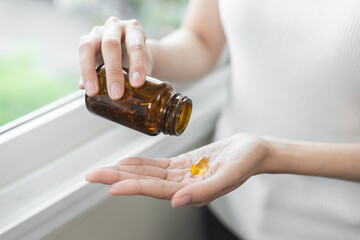 Dietary supplement concept, happy asian young woman hand holding fish oil pills, drugs medical...