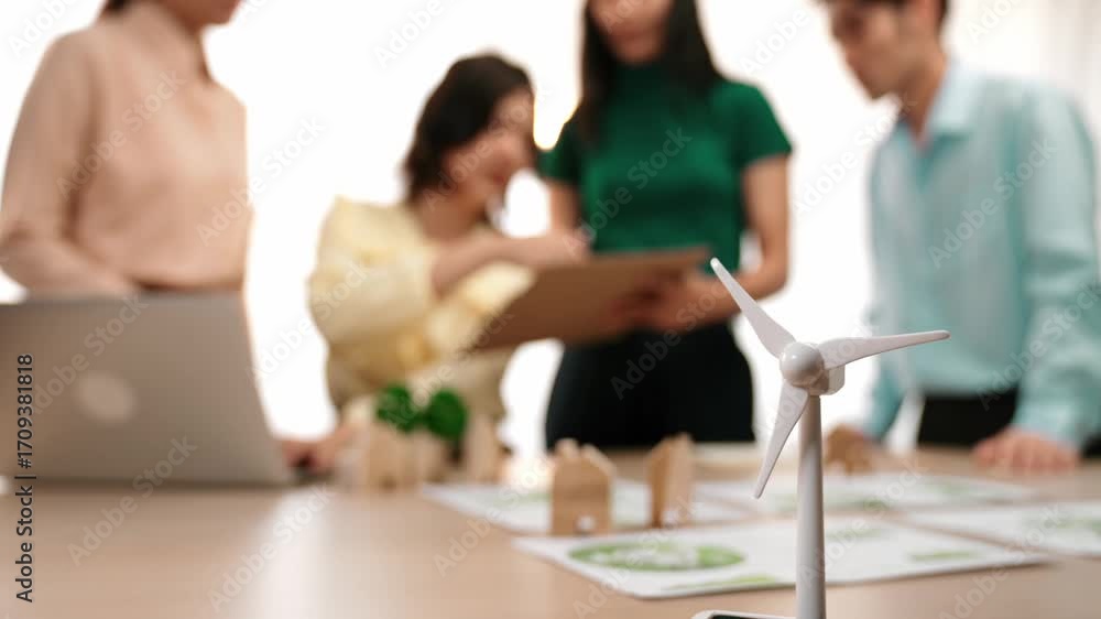 Poster windmill model represented using green energy and wooden block symbolized eco house was on table in 