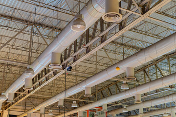 Obraz na płótnie Canvas Air conditioning ducts on the ceiling of a large building hall