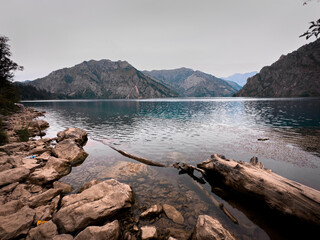 Rocky lakeshore and turquoise waters at Sary Chelek, Kyrgyzstan