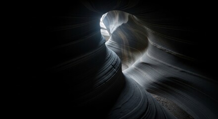 Sunlight streams into the dark depths of a slot canyon, illuminating the sculpted sandstone walls with ethereal light and shadow
