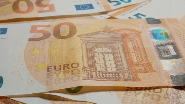 Experience an extreme close up of a 50 euro banknote revealing its unique features and designs. Discover the fine lines, patterns, and colors in this macro perspective.