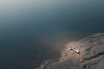 key rests on bright stone illuminated by beam of light essence of mystery