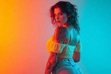 Woman with tattoos poses confidently against a colorful backdrop featuring warm orange and cool blue hues, showcasing her edgy fashion sense and captivating expression