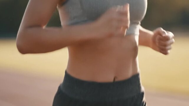 Athletic woman maintaining fitness through regular running on the sports track outdoor footage